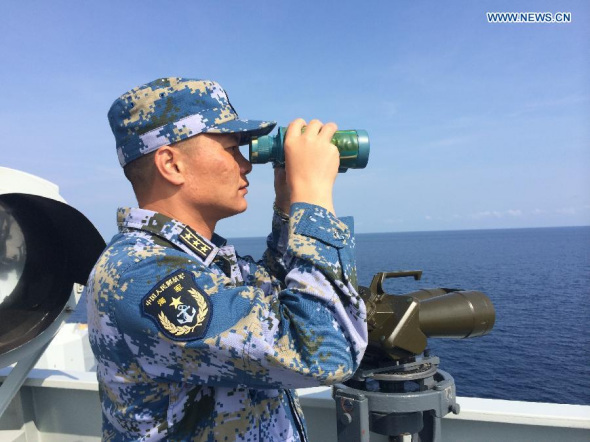 Captain Liu Zhonghu looks into distance with telescopes aboard Chinese navy ship Jinggangshan, March 20, 2014. The Chinese navy search fleets have been deployed toward the southern Indian Ocean where suspicious debris of missing Malaysia Airlines plane were spotted earlier Thursday. (Xinhua/Bai Ruixue) 