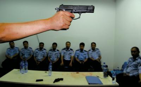 An instructor shows grassroot policemen the skills of using a gun at a training class. (File photo from the Beijing Times/Dong Shibiao)