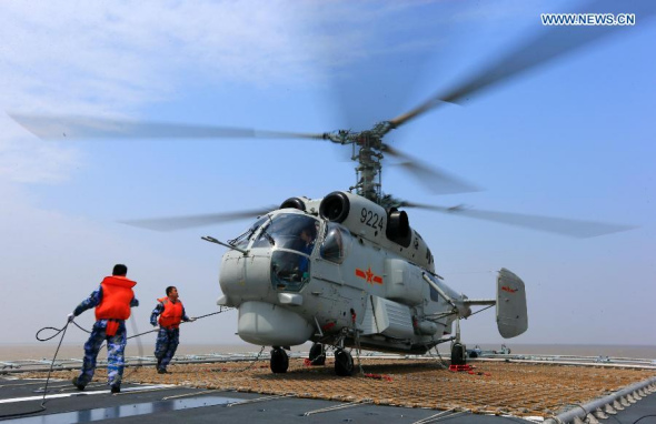 Crew members wash the engine of a helicopter on China's Zhengzhou missile destroyer, East China Sea, May 22, 2014. Naval ships from China and Russia left Shanghai for the East China Sea to take part in the Joint Sea-2014 exercise on Thursday. (Xinhua/Zha Chunming) 