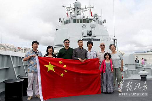 The picture shows local overseas Chinese who are visiting the guided missile destroyer Haikou of the Navy of the Chinese Peoples Liberation Army (PLAN) berthed in Pearl Harbor, Hawaii, display the national flag of the People's Republic of China (PRC) and pose for a family group photo on July 5, 2014, local time. (Chinamil.com.cn/Yu Lin)