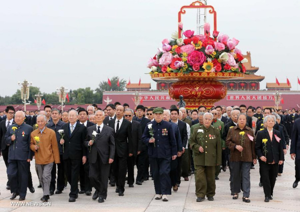 People present flowers to the deceased national heroes at the Monument to the People's Heroes in Tian'anmen Square, downtown Beijing, capital of China, Sept 30, 2014, on the occasion of the first Martyrs' Day. (Xinhua/Pang Xinglei)
