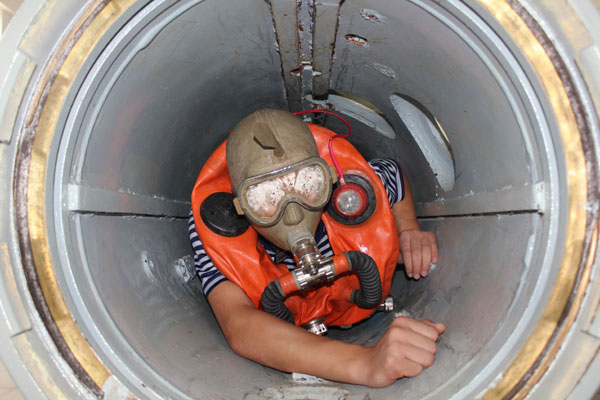 A sailor tries to escape from a pipeline during an emergency response drill. ZHOU YANCHENG/CHINA DAILY
