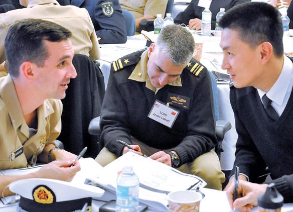A Chinese navy officer (right) talks with his counterparts in the US navy in Newport, Rhode Island, last week as part of a six-day exchange program. Twenty-nine officers visited military installations along the US East Coast. Provided to China Daily  
