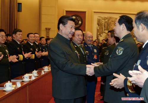 Chinese President Xi Jinping (C), also general secretary of the Communist Party of China (CPC) Central Committee and chairman of the Central Military Commission, shakes hands with deputies to the 12th National People's Congress (NPC) from the People's Liberation Army (PLA) and joins a plenary meeting of the PLA delegation during the third session of the 12th NPC in Beijing, capital of China, March 12, 2015. (Xinhua/Li Gang)