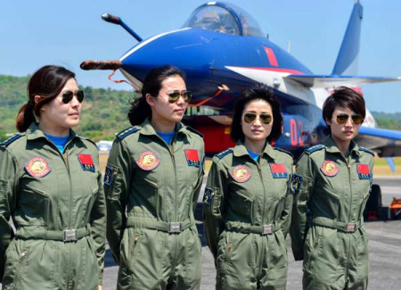 Standing with a J-10 fighter jet, four female pilots take a break at the biennial Langkawi International Maritime and Aerospace Exhibition in Malaysia on Tuesday. They were part of the aerobatics show. (Photo/Xinhua)