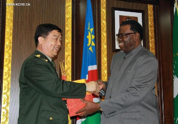 Chinese State Councilor and Defense Minister Chang Wanquan (L) shakes hands with Namibia's President Hage Geingob while presenting a gift to him in Windhoek, Namibia, March 30, 2015. (Xinhua/Wu Changwei)