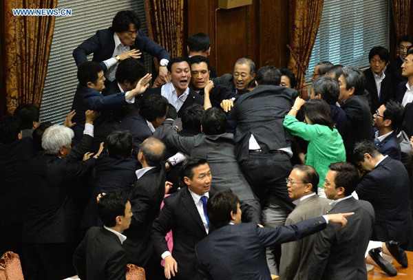 Japanese ruling and opposition lawmakers scuffle at the chamber in Tokyo, Japan, Sept. 17, 2015. A special committee under the upper house of the Japanese national Diet passed the controversial government-backed security-related bills amid chaos in the chamber. (Photo: Xinhua/Ma Ping)