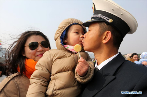 A naval officer kisses his child as he gets off board in a military port in Zhoushan, east China's Zhejiang Province, Feb. 5, 2016.  (Photo: Xinhua/Zeng Tao)