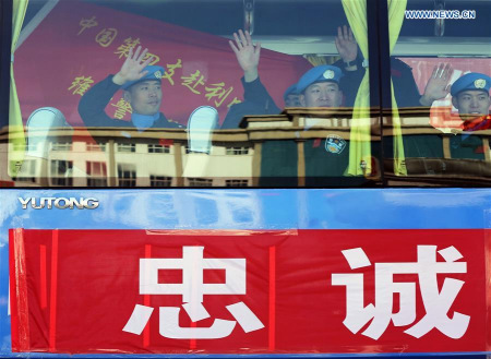 Members of a Chinese peacekeeping police squad for mission in Liberia wave to colleagues after a departure ceremony in Langfang, north China's Hebei Province, March 10, 2016. (Xinhua/Yin Gang)