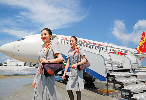 Flight attendants of Hainan Airlines arrive at Zhubi Reef in the South China Sea on Wednesday. The airplane was one of two airliners that landed for the first time on runways on Meiji Reef and Zhubi Reef. Feng Yongbin/China Daily