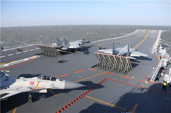 Carrier-based J-15 fighters prepare to take off from aircraft carrier Liaoning in a drill in the Bohai Sea. Photos by Mo Xiaoliang / for China Daily