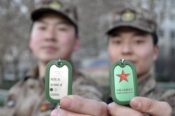 Two PLA servicemen show their new personal identification tags. (Photo/China.com)