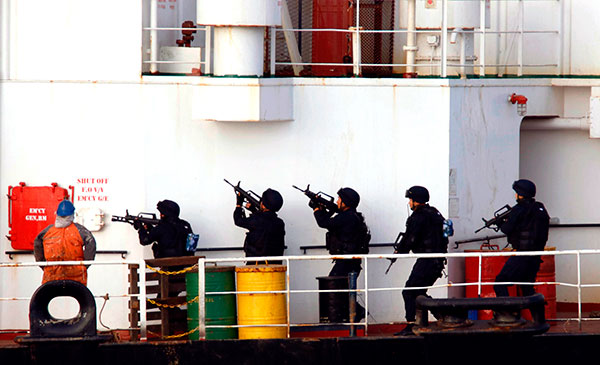 Members of the People's Liberation Army Navy rescue a Tuvalu-flagged cargo ship from pirates on April 9 in the Gulf of Aden. On Saturday, the PLA Navy rescued another vessel threatened by pirates, sending a helicopter to run the marauders off. The ship continued on its way. Niu Yunhai / China News Service