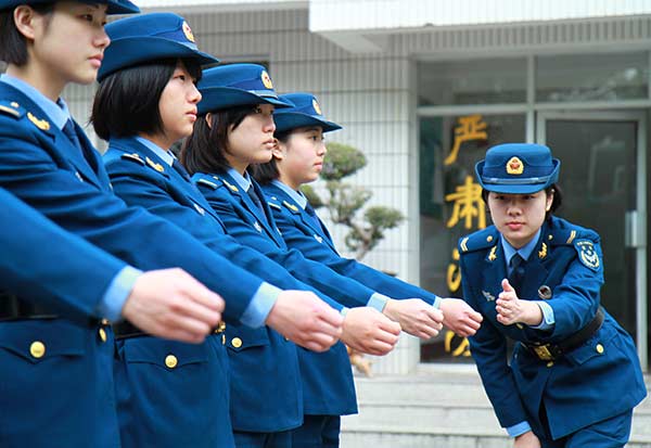 Deng Xin, a squad leader of the PLA Air Force, checks the posture of her soldiers during training. LI ZHONGWEI/CHINA DAILY