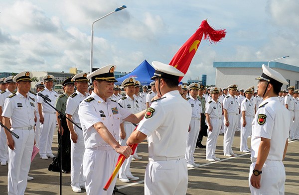Vice-Admiral Shen Jinlong, commander of the PLA Navy, presents a flag to the Djibouti Logistics Support Base garrison at their departure ceremony at a naval port in Zhanjiang, Guangdong province, on Wednesday. PROVIDED TO CHINA DAILY