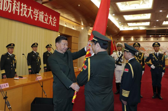Chinese President Xi Jinping, also general secretary of the Communist Party of China (CPC) Central Committee and chairman of the Central Military Commission (CMC), presents the heads of the People's Liberation Army (PLA) Academy of Military Science with the military flag in Beijing, capital of China, July 19, 2017. (Xinhua/Li Gang)