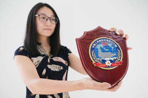 Zhang Yan holds a plaque featuring the badge for China's Liaoning aircraft carrier. (Photo: Li Hao/GT)