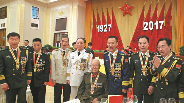 Recipients of the August 1 Medal pose for photos on Monday at a grand reception in Beijing's Great Hall of the People marking the 90th anniversary of the founding of the People's Liberation Army.
