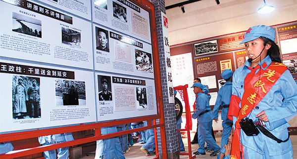 A volunteer at the education base in Chengmagang, Hubei province, discusses an exhibit related to former military figures. (Photos provided To China Daily)