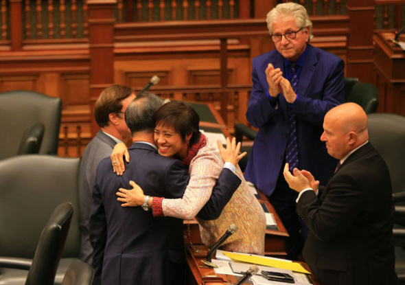 Soo Wong, a member of Canada's Ontario regional parliament, hugs a colleague in celebration after legislators passed a nonbinding motion designating a Nanjing Massacre Commemorative Day. A bill to make the day official awaits a third reading. (ZOU ZHENG/ XINHUA)