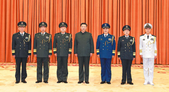 Xi Jinping (center), chairman of the Central Military Commission, poses for a group photo with Zhang Shengmin (first left), chief of the CMC Discipline Inspection Commission, after a promotion ceremony in Beijing on Thursday. The CMC promoted Zhang to the rank of general on Thursday.(Photo: Xinhua/Li Ganag)