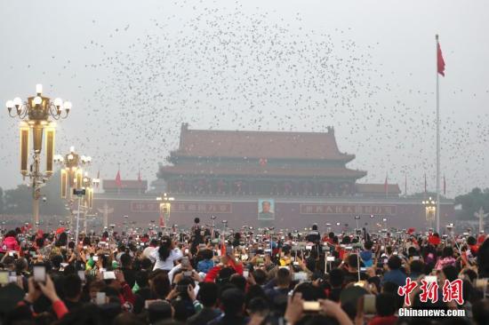 Visitors watch flag-raising ceremony at the Tiananmen Square. (File photo/China News Service)