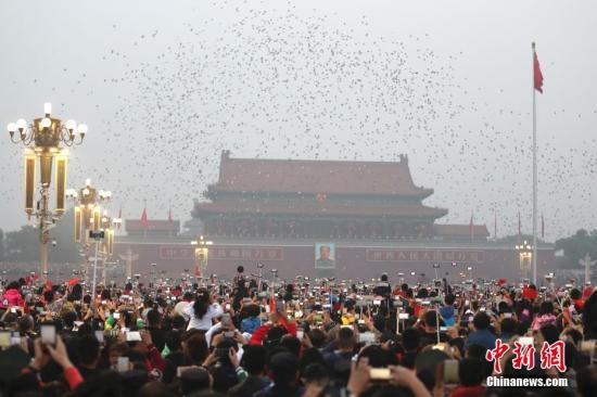 Visitors watch flag-raising ceremony at the Tiananmen Square. (File photo/China News Service)