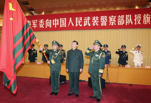 President Xi Jinping, who also is chairman of the Central Military Commission, confers an Armed Police flag on General Wang Ning (left), commander of the Armed Police, and General Zhu Shengling, political commissar of the force, in Beijing on Wednesday. (LI GANG/ XINHUA)