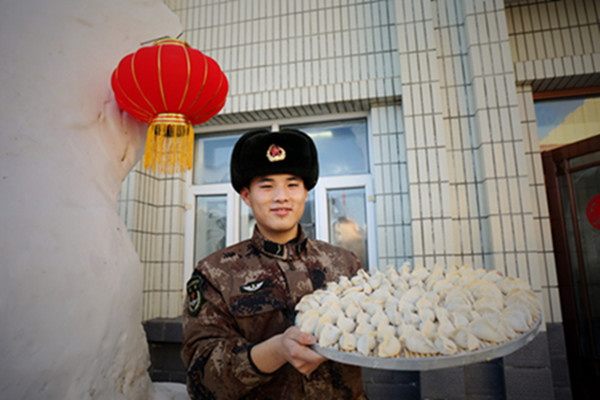 A soldier holds the dumplings made jointly by soldiers and civilians, Jan 15, 2018. (Photo by Wei Jianshun /for chinadaily.com.cn)