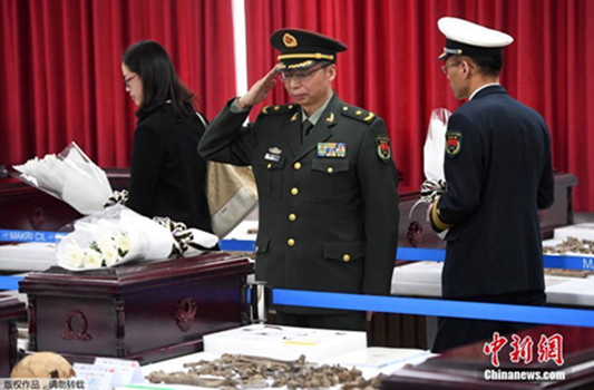 Du Nongyi, military attaché at the Chinese Embassy in South Korea, salutes the remains a Chinese People's Volunteer Army soldier who died fighting in the Korean War (1950-53), on Monday in Incheon, South Korea. The remains of 20 Chinese soldiers will be shipped back to China by a People's Liberation Army Air Force jet on Wednesday. (Photo/China News Service)