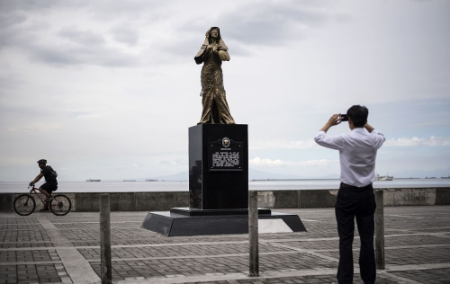 A man takes a picture of a memorial statue for World War II comfort women in Manila on January 11, 2018. (Photo provided to China Daily)