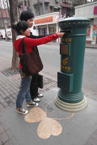 A young couple posts letters in Shanghai's only love mailbox on Tian'ai Road. Photo: CFP