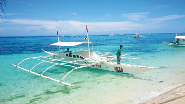 Boats dot the pristine waters of Bohol Island in central Philippines. Increasing numbers of mainland Chinese tourists are visiting the country, attracted by the spectacular natural scenery and abundant marine life. (ZHANG HAIZHOU/CHINA DAILY ASIA WEEKLY)