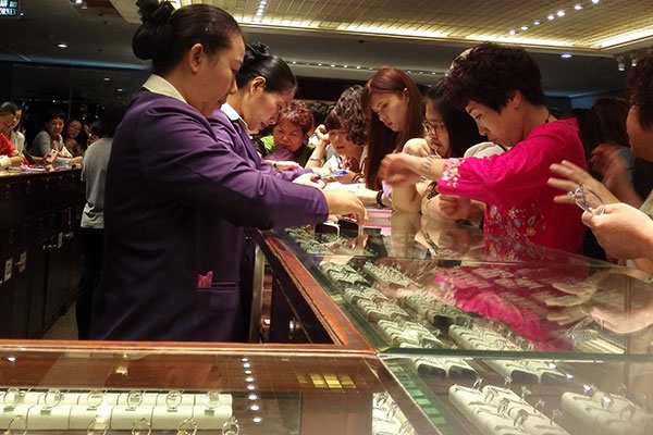 Chinese visitors shop at a jewelry store in Thailand.(Photo by Liu Yunmin/Liu Debin/Xu Lin/China Daily)