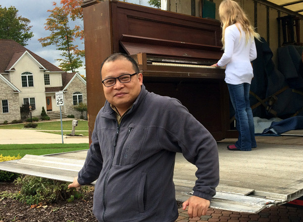 He Lijun poses in front of a piano he bought in Ohio, the United States, in 2012. (Provided To China Daily)