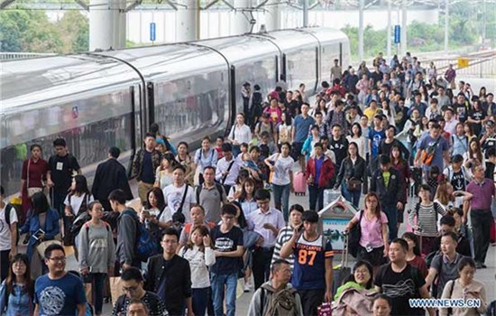 Passengers walk out of the Nanjing Railway Station in Nanjing, Oct 6, 2016. The country witnessed a travel peak on the last two days of the week-long National Day holiday as people started to return to school and work.(Photo/Xinhua)