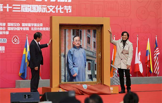 Wang Qijun (right),donated his oil painting Cai Yuanpei to Lin Jianhua, president of Peking University, in the opening ceremony of the 2016 Peking University International Culture Festival. (Photo provided to www.chinadaily.com.cn)