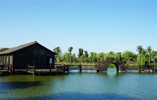 Hongshancun, about a 20-minute drive from Wuzhen, hosts lush trees, wooden bridges, lakes and historical buildings. (Photo provided to China Daily)