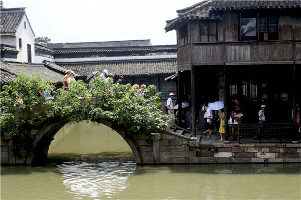 Traditional houses, featuring gray rooftops and white walls, flank the riversides. (Photo provided to China Daily)