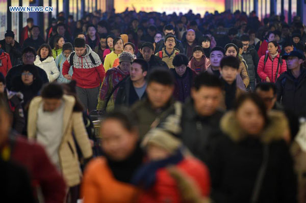 Arriving passengers exit the Beijing Railway Station in Beijing, capital of China, Feb. 12, 2016. (Photo/Xinhua)