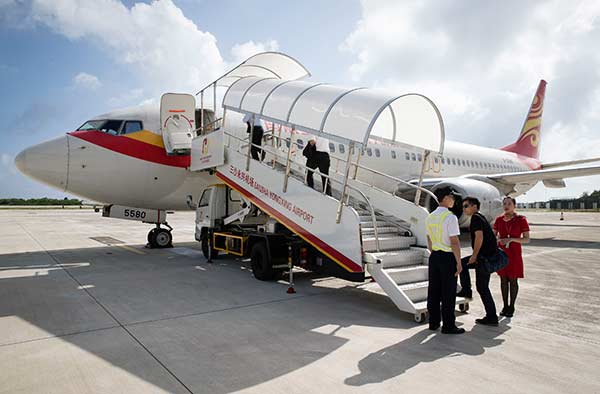 Passengers board a flight at an airport on Yongxing Island. The first regular civil charter flight between Haikou, capital of Hainan province, and the island was operated on Thursday.Song Guoqiang / For China Daily