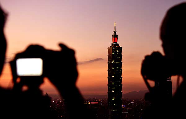 People take photos of the landmark Taipei 101 building in Taiwan in January. (Photo/Xinhua)