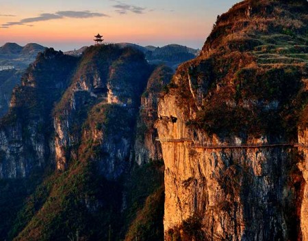 Passes built on the cliffs and a glass suspension bridge are among the highlights of Zhusha ancient town in Guizhou, which has turned from mercury mine site to a tourist hot spot. (Photo provided to China Daily)