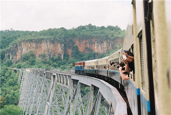A train runs on a bridge in Myanmar, taking Qi Dong on another signature tour.