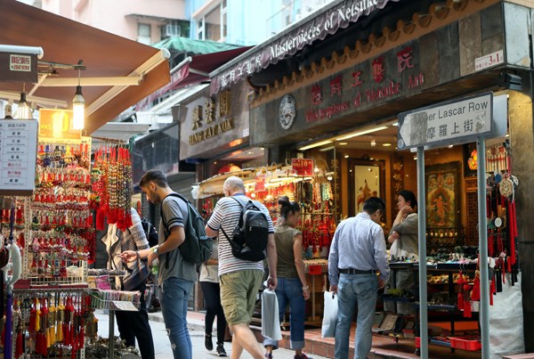 Visitors buy souvenirs at a street market. (Photo by Li Peng/Xinhua)