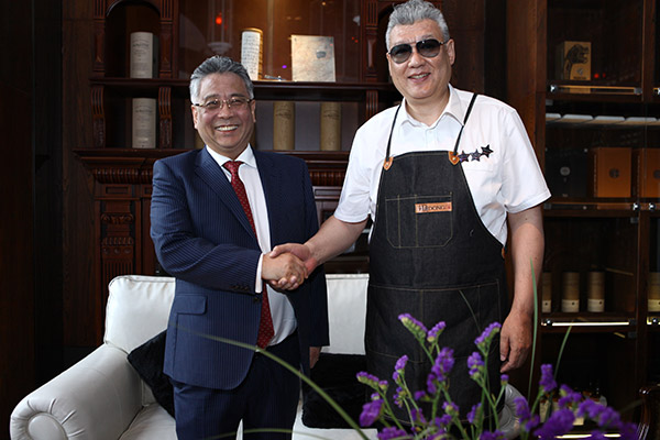 Celebrity chef Dong Zhenxiang, founder of the Peking roast duck restaurant chain Dadong, with Liu Zinan, the president of the China and North Asia-Pacific region, Royal Caribbean International. With the opening of Dadong Wonderland on two Royal Caribbean cruise ships, guests will be able to enjoy Peking roast ducks.(Photo provided to China Daily)