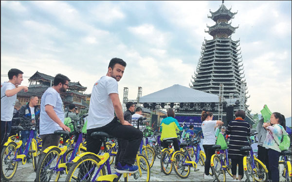 Foreign tourists ride shared bikes to China's first ethnic-themed outdoor festival held in Rongjiang, Guizhou province, earlier this year. The festival involves a combination of sports and tourism with characteristics of Dong and Miao ethnic groups.Deng Gang/For China Daily