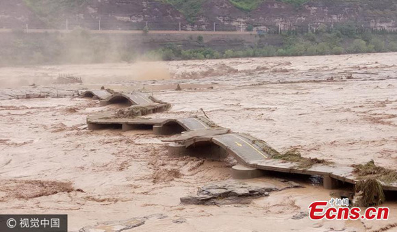 Muddy floodwater surges to totally cover the Hukou Waterfall in the Yellow River located at the border between Shanxi and Shaanxi provinces, July 27, 2017. (Photo/VCG)