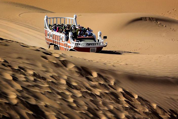Photo taken on Aug 6, 2015 shows people visiting Xiangshawan Desert in Ordos, North China's Inner Mongolia autonomous region. (Photo/Xinhua)