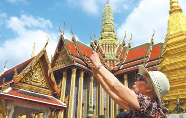 A tourist enjoys the sights in Bangkok, Thailand. More Chinese travelers prefer individualized travel. (Photo/China Daily)